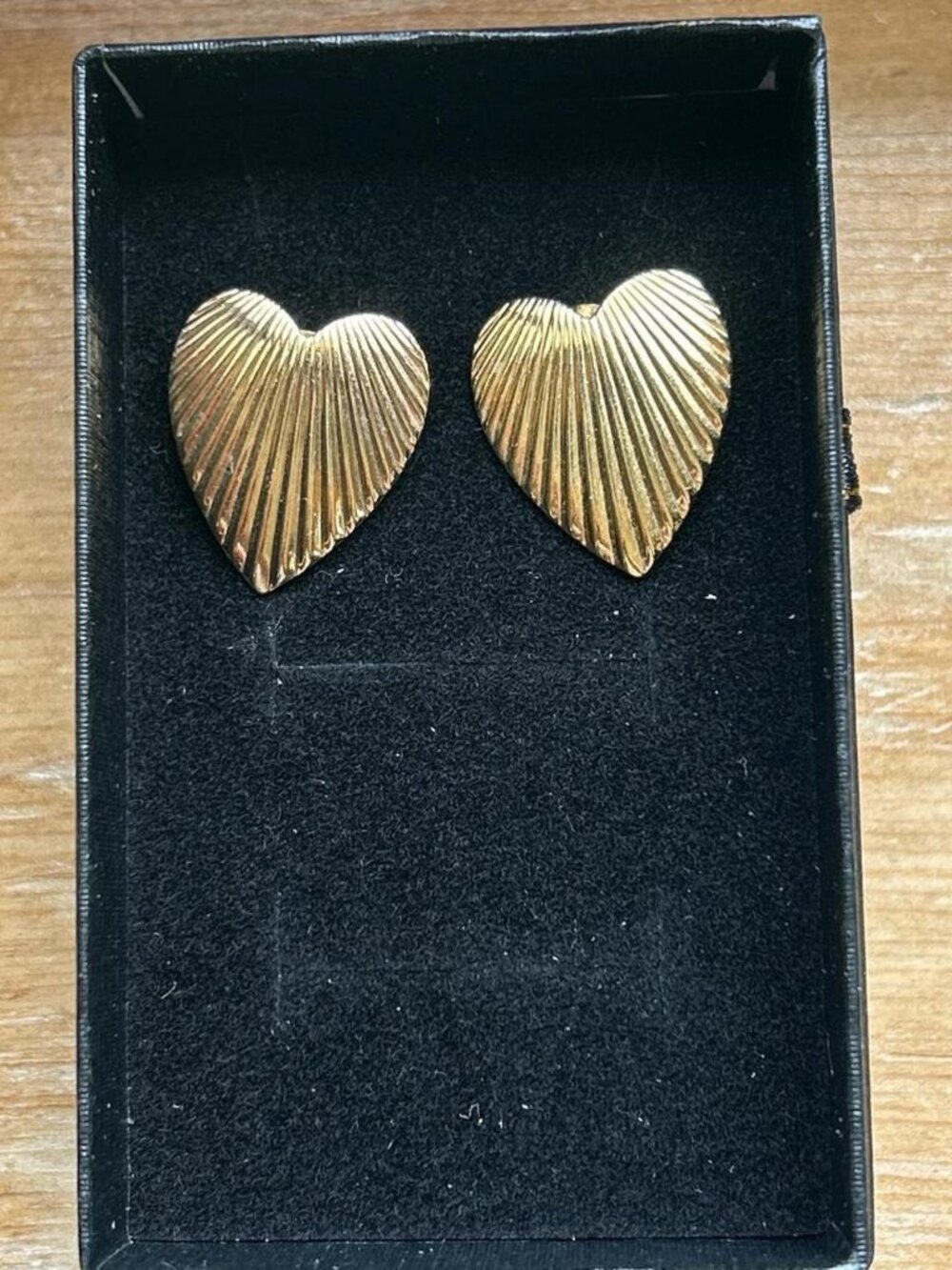 Gold colored heart-shaped earrings. Costume jewelry